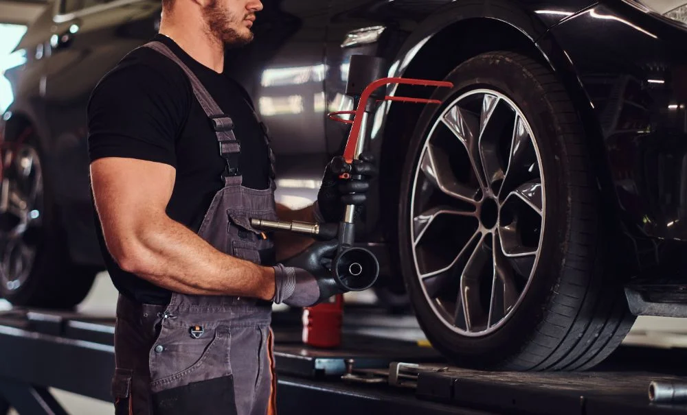 Mechanic changing a car wheel in a garage